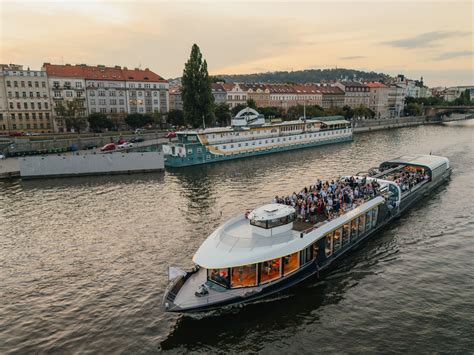 Fotografia lode na Vltave v noci s vysvieteným Pražským hradom v pozadí
