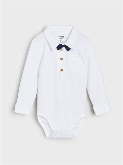 Detail bieleho body s golierom a modrým motýlikom.