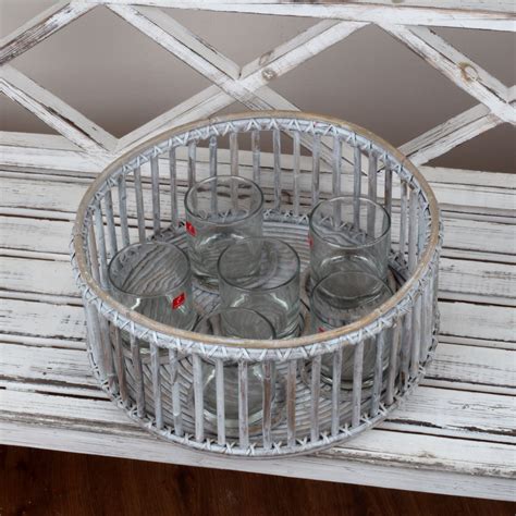 Detailný záber na okrúhly prútený svietnik na stole so zapálenými sviečkami