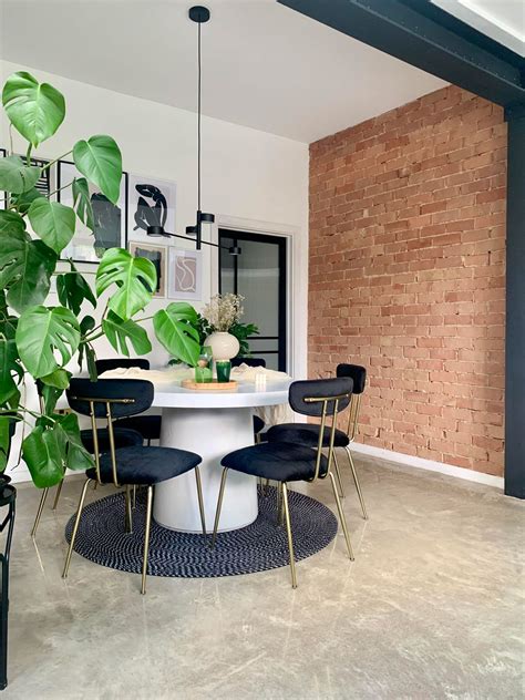 Detailne vyzdobená vianočná obývačka s červenou tehlovou stenou, svetelnými reťazami a prírodnými dekoráciami