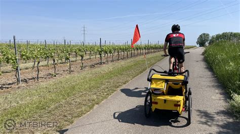 Tematická fotografia: cyklista s úsmevom na tvári, v pozadí bicykel a hory