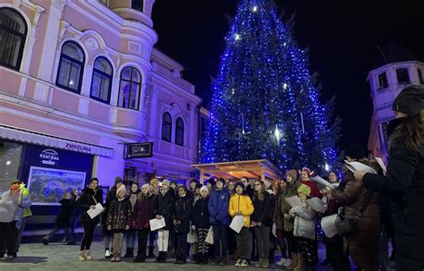 Vianočná atmosféra s rodinou pri stromčeku a speve kolied