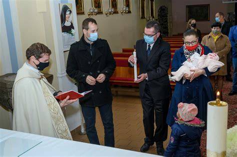 fotografia kňaza hovoriaceho s rodičmi a krstnými rodičmi