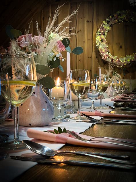 Stôl s kvetinovými aranžmánmi, menovkami a sviečkami