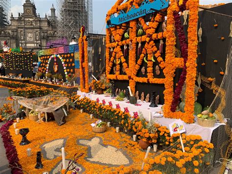 oltár ofrenda s kvetmi, jedlom a fotografiami počas Día de los Muertos