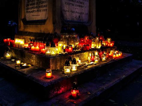 Fotografia cintorína so zapálenými sviečkami počas dušičkového obdobia