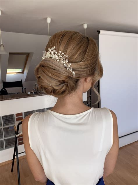 Detailný záber na prepracovaný nízky svadobný drdol so zapletenými prvkami