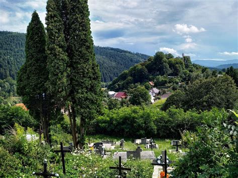 Tematické foto: Pohľad na cintorín s horiacimi sviečkami a kvetinovými dekoráciami počas Dušičiek