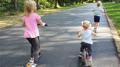 Deti jazdiace na kolobežkách v parku