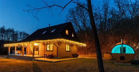 Zasnežená horská chata s osvetlenými oknami, symbolizujúca romantický a pokojný Silvester v prírode