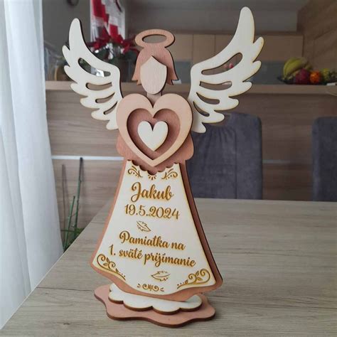 Drevený anjel s gravírovaným menom a dátumom ako pamiatka na prvé sväté prijímanie