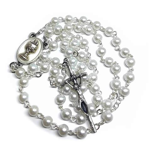 Detailný záber na elegantný perličkový ruženec s krížikom a motívom Eucharistie, ideálny ako darček k prvému svätému prijímaniu.