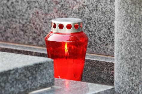 Cintorín so sviečkami a kvetmi počas Dušičiek
