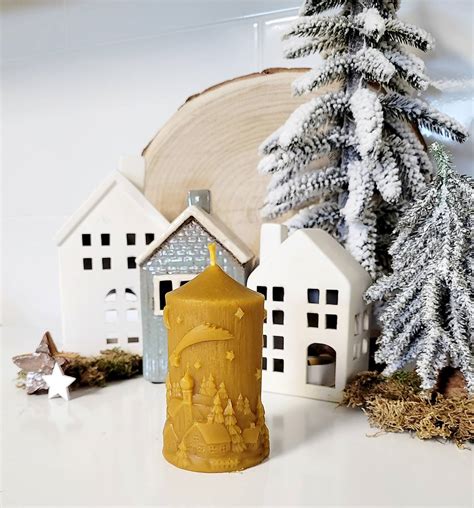 fotografia dreveného LED svietnika so zimnou krajinkou a zasneženého kostolíka