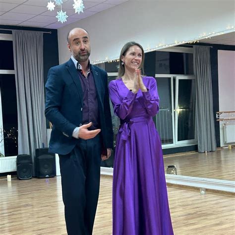 Pár trénujúci tanečnú choreografiu v tanečnom štúdiu pod dohľadom inštruktora