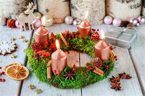 Adventný veniec so zapálenými sviečkami, symbolizujúci očakávanie Vianoc