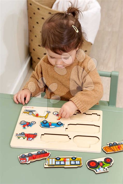 Dvojročné dieťa skladajúce drevené puzzle s veľkými dielikmi
