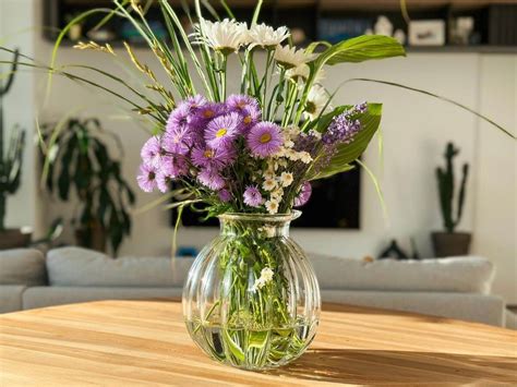 Štýlová váza s čerstvými kvetmi ako stredový prvok na kuchynskom stole