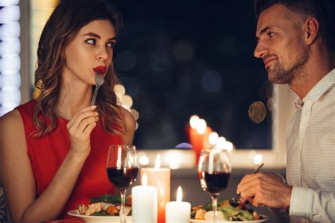 Dvojica si vymieňa darčeky pri romantickej večeri.