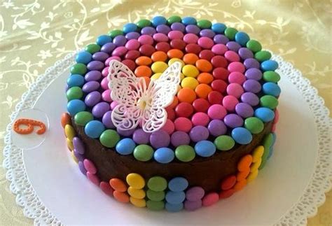 Detská narodeninová torta zdobená farebnými lentilkami a lízankami