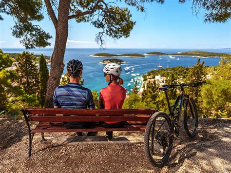 Dvojica sediaca na lavičke, objímajúca sa, s výhľadom na krajinu