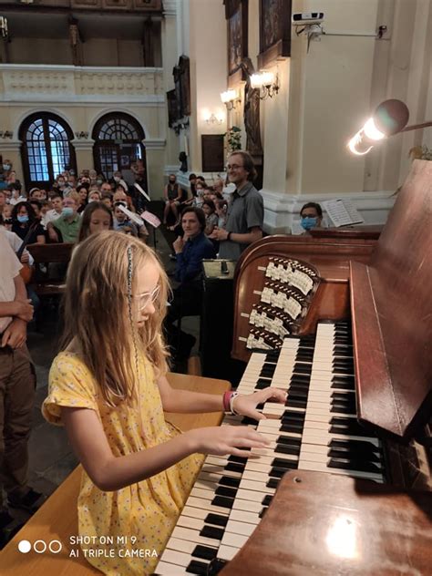 mladá organistka sediaca pri kostolnom organe a hrajúca