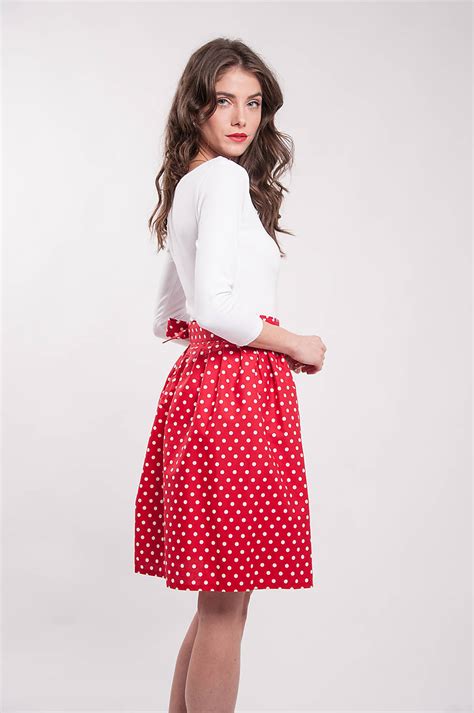 Ilustrácia ikonických prvkov kostýmu Minnie Mouse: červená bodkovaná sukňa, čierna čelenka s ušami a výrazná mašľa