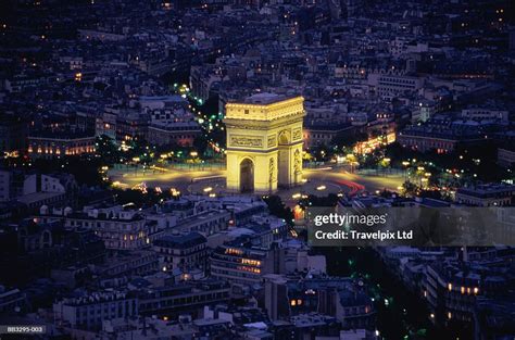 Champs-Élysées illuminated at night with the Arc de Triomphe in the distance