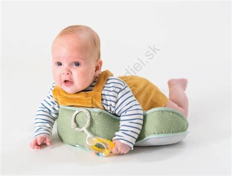 Tematické foto bábätka objavujúceho svet, ležiaceho na brušku s hračkou