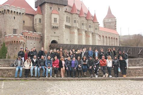 Skupina usmievavých študentov obdarúva svojich učiteľov, symbolizujúca vďačnosť