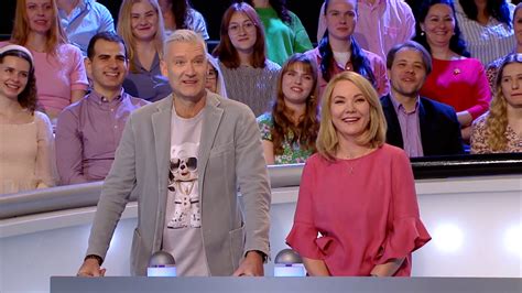Skupina usmievavých ľudí na stretnutí po rokoch, jedna osoba drží mikrofón a hovorí príhovor