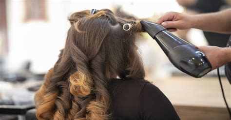 Stylistka upravujúca vlasy modelke pred slávnostnou udalosťou