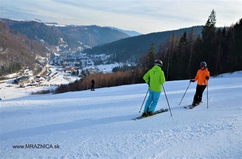 Rodina lyžujúca na miernom svahu s detským vlekom v slovenskom lyžiarskom stredisku.