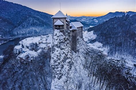 Panoramatický pohľad na Oravský hrad v zime pri západe slnka.