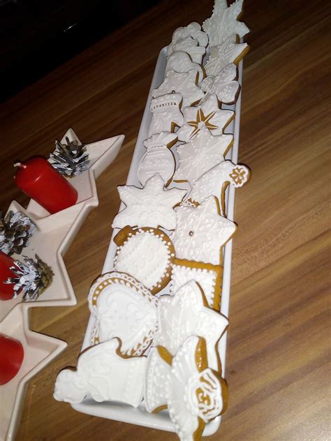 Detail zdobenia medovníkového svietnika bielou polevou a prichytenými dekoráciami.