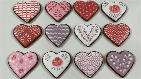 Proces zdobenia medovníkových srdiečok bielou polevou pomocou cukrárskeho vrecka.