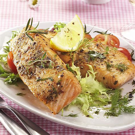 Fotografia pečeného lososa s citrónovými plátkami a bylinkami