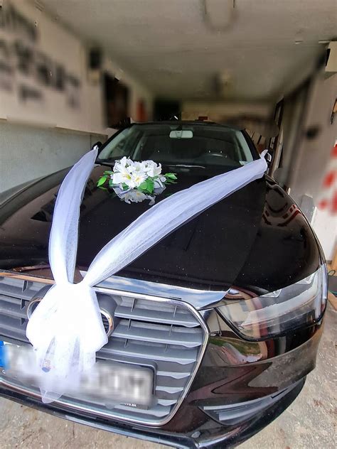 Detailná fotografia bielej ratanovej srdcovej dekorácie na kapotu auta s prísavkami.