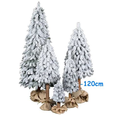 Zasnežený umelý vianočný stromček na drevenom kmeni v jutovom vreci