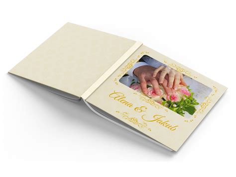 Fotokniha alebo album otvorený na fotke svadobného páru, s rubínovými ozdobami