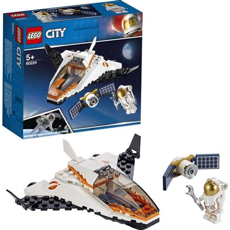 chlapec skladá LEGO stavebnicu, hotové modely LEGO áut a vesmírnej lode