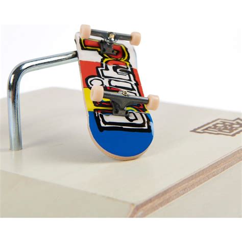 dve ruky hrajúce sa s fingerboardom na miniatúrnej rampe