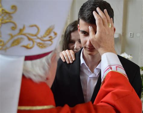 Mladí ľudia prijímajú sviatosť birmovania v kostole