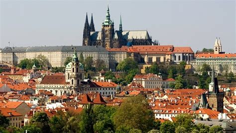 Panoramatický pohľad na Pražský hrad a Hradčany z diaľky, ideálne za súmraku s rozsvietenými svetlami