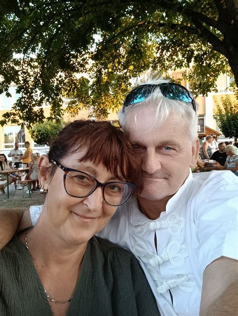 Tematická fotografia: Rečník s mikrofónom pred skupinou usmievajúcich sa ľudí, držiacich zdvihnuté poháre