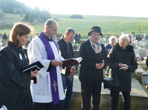 Tematické foto s kňazom a veriacimi pri modlitbe za zosnulých na cintoríne