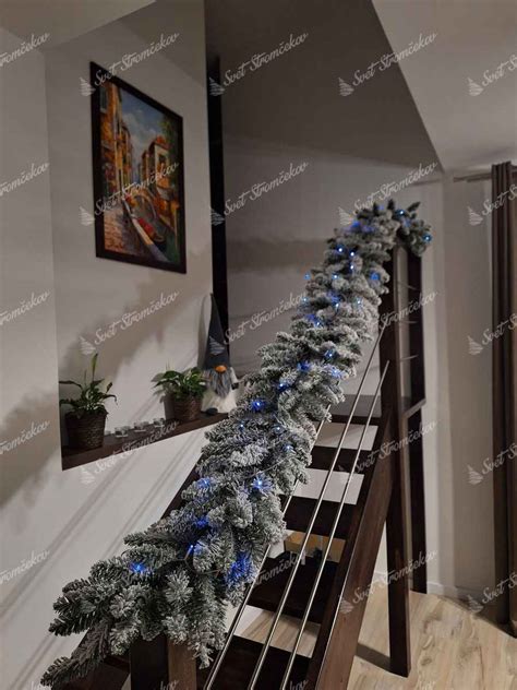 Detail vianočnej girlandy s ozdobami na zábradlí schodiska