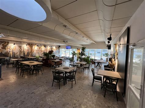 Slávnostné otvorenie reštaurácie s prestrihávaním pásky a skupinou usmievavých ľudí