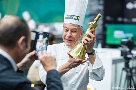 Šéfkuchár s tímom v kuchyni pripravuje jedlo, zdôrazňujúc kvalitu a vášeň