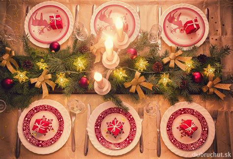 Zátišie so štedrovečerným stolom, vianočným stromčekom a tradičnými symbolmi (oblátky, med, cesnak, jablko)